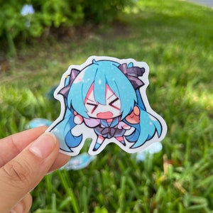 K&ouml;nnte beinhalten: Ein blauer und wei&szlig;er Anime-Charakter-Aufkleber mit einem &uuml;berraschten Ausdruck. Der Charakter hat lange blaue Haare und tr&auml;gt ein schwarz-wei&szlig;es Outfit.