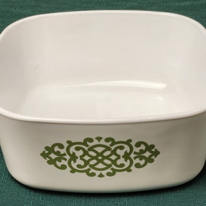 May include: White ceramic baking dish with green floral design. The dish has two handles.