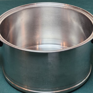 May include: A stainless steel pot with black handles. The pot is empty and has a shiny surface.