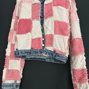 Op de afbeelding: Een roze en wit patchwork denim jack met knoopsluiting. Het jack heeft een cropped pasvorm en lange mouwen.