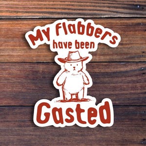 Op de afbeelding: Witte sticker met rode tekst die "My flabbers have been Gasted" luidt. Een cartoonbeer met een cowboyhoed bevindt zich in het midden van de sticker.