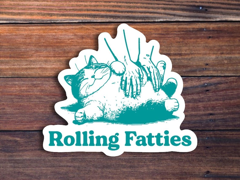 May include: A teal blue sticker with a cartoon illustration of a cat being rubbed on its belly by two hands. The text "Rolling Fatties" is printed below the cat.