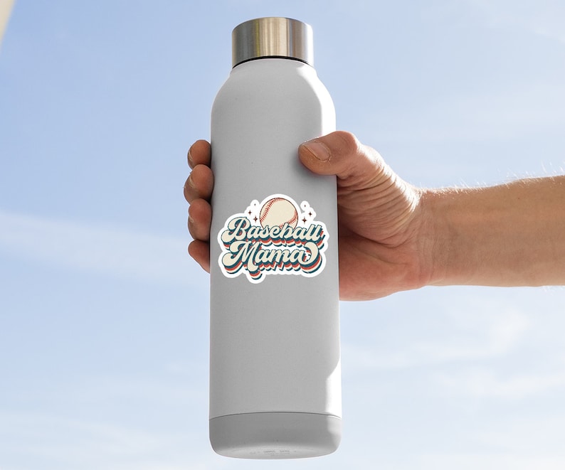 Pode incluir: Uma garrafa de &aacute;gua branca com um adesivo de beisebol de estilo retro que diz "Baseball Mama" com um gr&aacute;fico de beisebol.