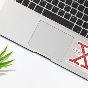 May include: Red and white sticker with the text "Generation X 1965 - 1980" and the text "Raised on house water and video met" on a silver laptop.