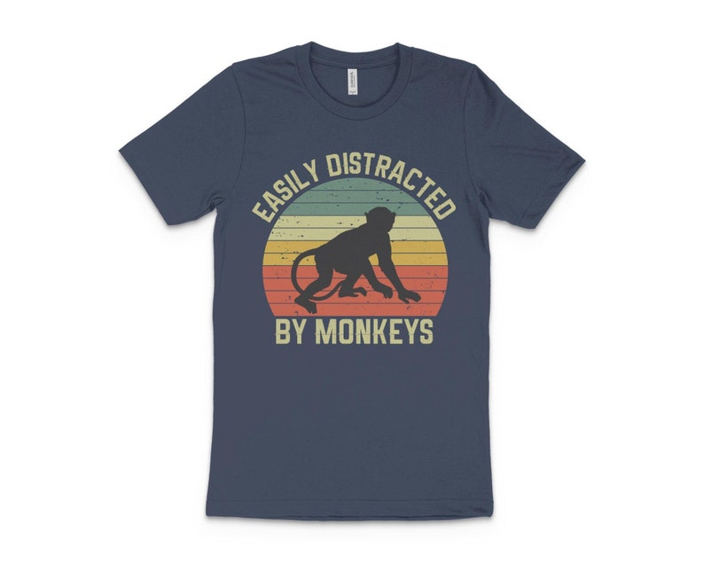 May include: A navy blue t-shirt with a vintage-style graphic of a monkey and the text "Easily Distracted By Monkeys".