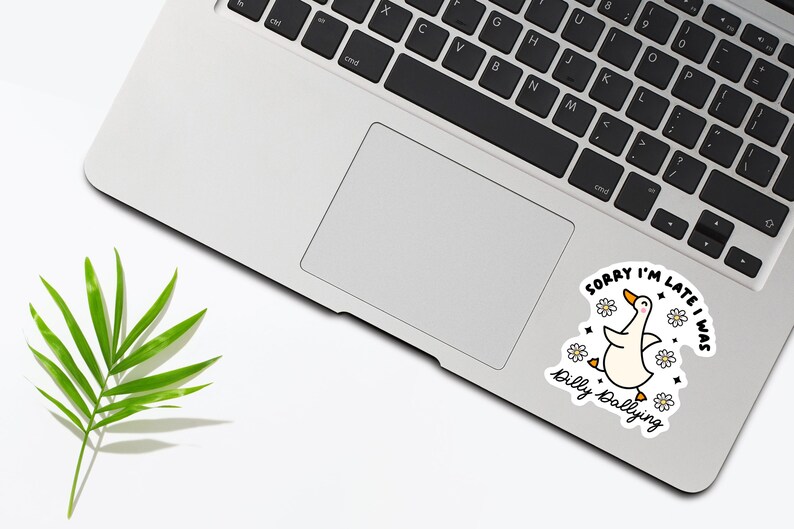 May include: A white laptop with a sticker of a cartoon goose with the text "Sorry I'm late I was dilly dallying".
