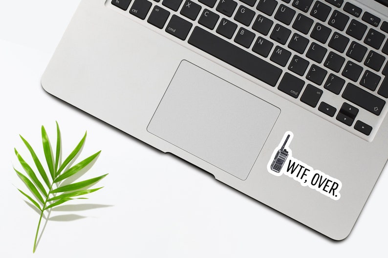 May include: A laptop computer with a sticker of a walkie-talkie and the text "WTF, OVER." on the bottom right corner of the trackpad.