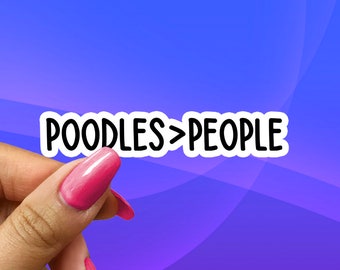 May include: A white sticker with black text that reads "POODLES>PEOPLE". A hand is holding the sticker.