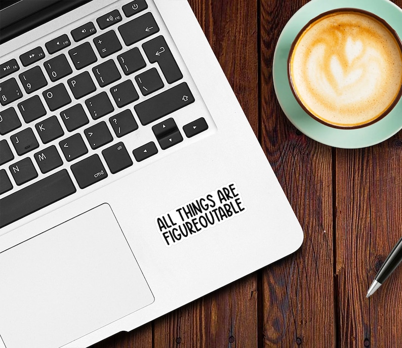 May include: A white laptop computer with a black keyboard and a black and white sticker that says "ALL THINGS ARE FIGUREOUTABLE" on the top right corner of the laptop.