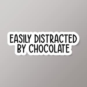 May include: White sticker with black text that reads "Easily Distracted by Chocolate".