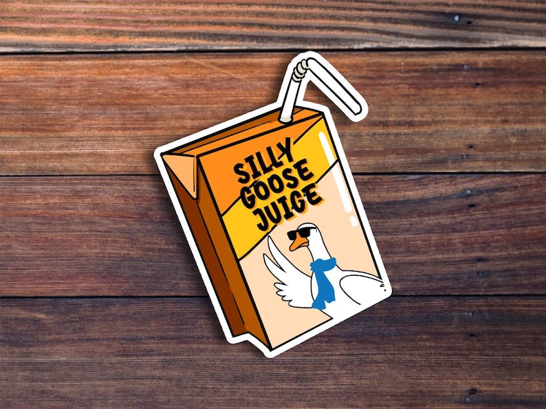 Puede incluir: Una pegatina de una caja de jugo de dibujos animados con un ganso que lleva gafas de sol y una bufanda azul. La caja de jugo es naranja y amarilla y dice "Silly Goose Juice" en la parte delantera.