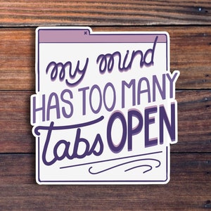 Peut inclure: Un autocollant avec un design violet et blanc qui dit "my mind has too many tabs open". L'autocollant est en forme de fen&ecirc;tre d'ordinateur avec un bouton de fermeture dans le coin sup&eacute;rieur droit.