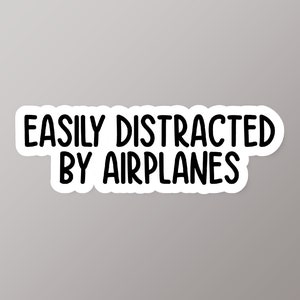 May include: White sticker with black text that reads "Easily distracted by airplanes".