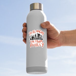 May include: A gray stainless steel water bottle with a black and white sticker that says "I'm not angry I'm from Philly" with a silhouette of the Philadelphia skyline.