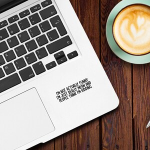 May include: A white laptop computer with a black keyboard and a sticker on the right side of the trackpad that reads "I'm not actually funny I'm just really mean and people think I'm kidding."