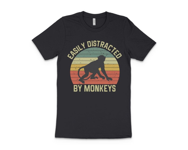 May include: Black t-shirt with a vintage-style graphic of a monkey and the text "Easily Distracted By Monkeys".