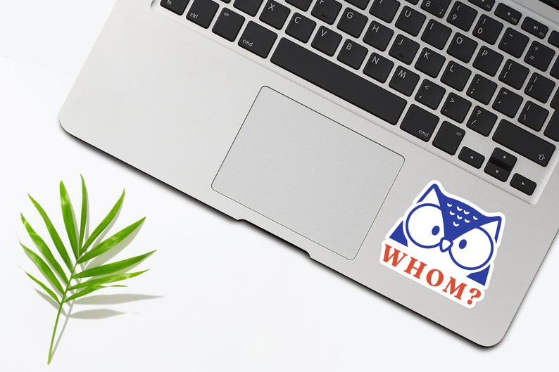 May include: A blue and white owl sticker with the text "WHOM?" in red letters on a silver laptop.
