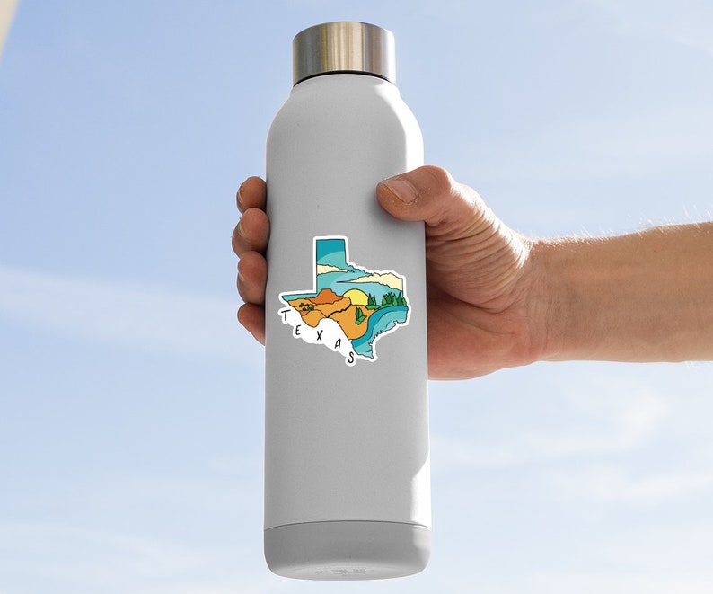 May include: A stainless steel water bottle with a sticker of the state of Texas. The sticker features a colorful illustration of the state with a sunset, mountains, and a river. The text "TEXAS" is written in white letters on the sticker.