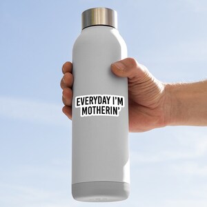 Puede incluir: Una botella de agua gris con una pegatina negra que dice "EVERYDAY I'M MOTHERIN'" en ella.