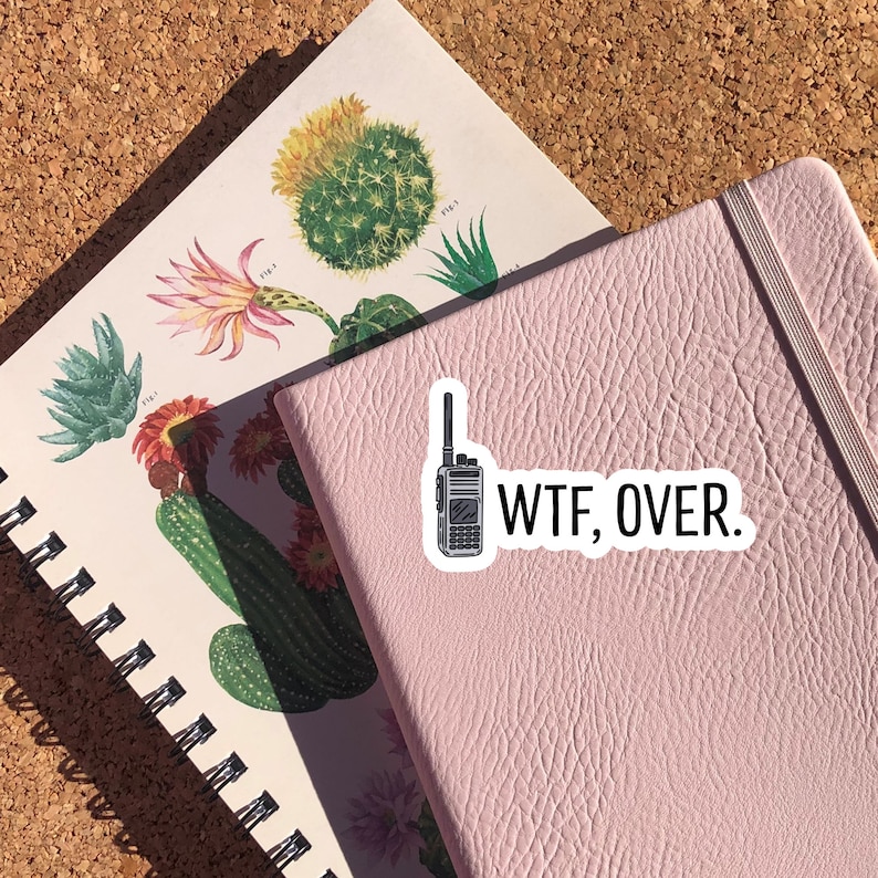 May include: A pink notebook with a black and white sticker of a walkie talkie and the text "WTF, OVER."