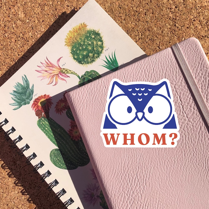 May include: A pink notebook with a blue and white owl sticker that says "Whom?" on it.