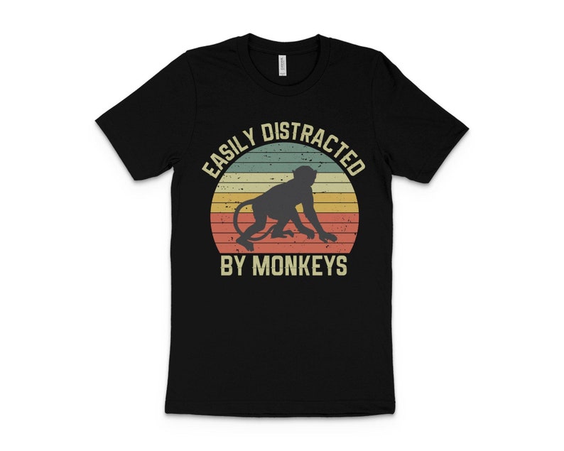 May include: Black t-shirt with a vintage-style graphic of a monkey and the text "Easily Distracted By Monkeys".