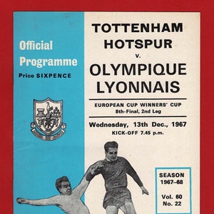 May include: A black and white photograph of two football players in action. The player on the left is wearing a white shirt and the player on the right is wearing a red shirt. The photo is from a 1967 European Cup Winners' Cup match between Tottenham Hotspur and Olympique Lyonnais. The text on the programme reads "Tottenham Hotspur v. Olympique Lyonnais, European Cup Winners' Cup, 8th-Final, 2nd Leg, Wednesday, 13th Dec., 1967, KICK-OFF 7.45 p.m., Season 1967-68, Vol. 60, No. 22."