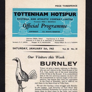 May include: A black and white program for a football match between Tottenham Hotspur and Burnley. The program cover features a blue and white crest with a football and a rooster. The text on the cover reads "Tottenham Hotspur Football and Athletic Company Limited Official Programme." The program is dated Saturday, January 5th, 1963.