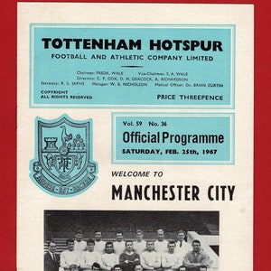 May include: A black and white photo of a soccer team, the Manchester City Football Club, posing for a team photo. The team is wearing white jerseys with black and red trim. The team is standing in front of a wooden fence. The photo is from a 1967 program for a Tottenham Hotspur soccer match.