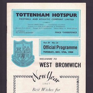 Pode incluir: Um programa de futebol azul e branco para um jogo de Tottenham Hotspur contra West Bromwich Albion. A capa do programa apresenta o brasão do Tottenham Hotspur e o texto "Official Programme" com a data "Tuesday, Dec. 27th, 1966".