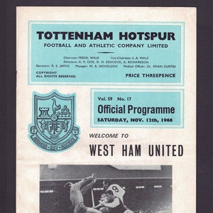 May include: Black and white photograph of a football match. A player in a white shirt jumps to head the ball, while a player in a dark shirt attempts to block him. The text "Spurs v. Aston Villa: Alan Gilzean's header beats goalkeeper Colin Withers, but goes over the bar. Photo by Atkins Photos, Tottenham" is at the bottom of the image.