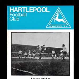 Op de afbeelding: Een zwart-witfoto van een voetbalwedstrijd tussen Hartlepool Football Club en Reading Football Club. De wedstrijd werd gespeeld op woensdag 6 november 1974, als onderdeel van de vierde divisie van de Football League. De bijschrift luidt "Seizoen 1974-75, Woensdag 6 november 1974, Football League Fourth Division, Reading, Aftrap: 19:15 uur, Officieel wedstrijdmagazine, 6p."