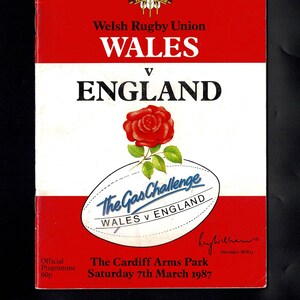 Könnte beinhalten: Ein Vintage-Rugby-Programmcover in Rot und Weiß. Es zeigt das Logo der Welsh Rugby Union, die Worte "WALES v ENGLAND" und eine rote Rose. Der Text "The Gas Challenge" ist ebenfalls vorhanden. Datum: Samstag, 7. März 1987.