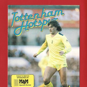 May include: A vintage magazine cover featuring a soccer player in a yellow uniform with the text "Tottenham Hotspur" in a blue and yellow font. The cover also includes the text "Leeds United Official Programme" and "M&M Spanish Homes".