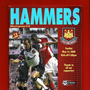 Può includere: Una copertina di programma di partita di calcio del West Ham United con una foto di due giocatori in azione. Il programma è per la partita contro il Leeds United di domenica 14 maggio 2000. Il programma è intitolato "Hammers" e include lo stemma della squadra e gli sponsor.