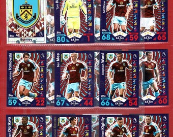 May include: A collection of Burnley Football Club trading cards, featuring player portraits and team logo. The cards have a red and blue design with player names, stats, and team information.
