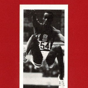BOB BEAMON - ATLETIEK Trade Card - Olympische grootheden - 1979 Atleetkaart - Wereldrecord Olympisch kampioen verspringen - Brooke Bond (OS01)