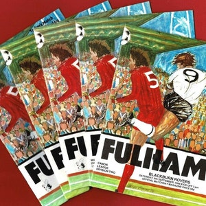 Może przedstawiać: Stosik pięciu programów meczowych Fulham Football Club przeciwko Blackburn Rovers. Okładka przedstawia kolorową ilustrację piłkarza w czerwono-białej koszulce kopiącego piłkę w kierunku piłkarza w biało-czarnej koszulce. Tekst na okładce brzmi "Fulham" i "Blackburn Rovers".