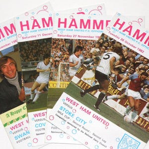 May include: Four vintage West Ham United Football Club match day programmes from the 1980s. The programmes feature the team's logo and the words "Hammer" and "West Ham United".