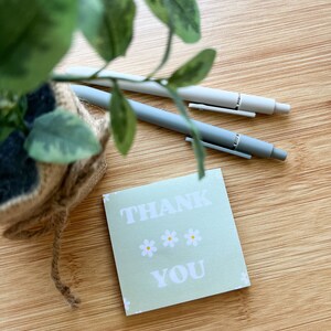 May include: A green thank you card with white daisies and the text "THANK YOU" in white letters.