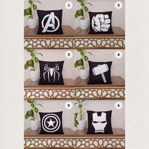 Peut inclure: Six coussins noirs avec des logos de super-héros blancs. Les logos sont : le 'A' des Avengers, le poing de Hulk, Spiderman, le marteau de Thor, le bouclier de Captain America et le visage d'Iron Man.