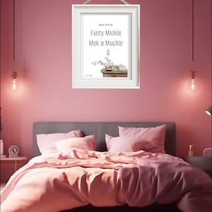 Puede incluir: Una impresión enmarcada en blanco con el texto "Never give up. Every Mickle Mek a Muckle." y una ilustración de acuarela de un arreglo floral en un jarrón sobre una mesa de madera.