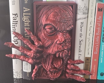 Angolo lettura con zombie sbircianti e decorazioni gotiche per scaffali in stile horror.