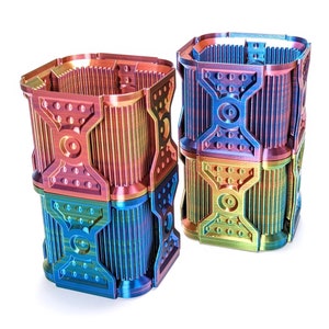 May include: Two stacked, multi-coloured, geometric, 3D printed containers with a rainbow iridescent finish.