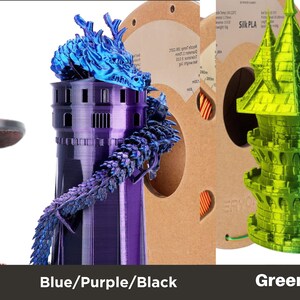Puede incluir: Tres objetos impresos en 3D, un gato negro y rojo, una torre morada con un drag&oacute;n azul y un castillo verde y amarillo. Los objetos est&aacute;n impresos con filamento que tiene un brillo met&aacute;lico.