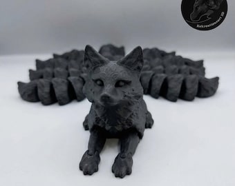 May include: A black 3D-printed fox figurine with a multi-segmented tail. The fox is in a seated position, with its front paws extended. The tail fans out behind it. The figurine has detailed facial features and a textured surface.