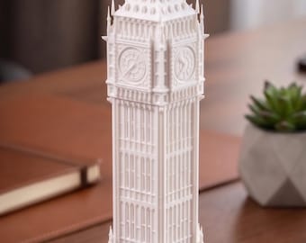 May include: A white 3D printed model of the Elizabeth Tower, commonly known as Big Ben, featuring intricate architectural details including the clock faces, arched windows, and a pointed spire. The structure is tall, slender, and stands upright.