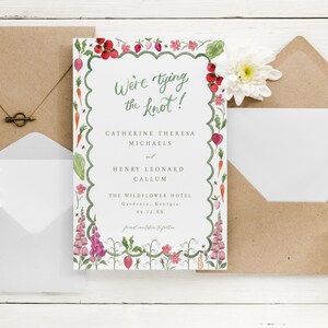 May include: A wedding invitation with a floral border featuring a watercolor illustration of flowers, vegetables, and insects. The text reads "We're tying the knot!" Catherine Theresa Michaels and Henry Leonard Callum. The Wildflower Hotel, Gardenia, Georgia, 04.12.XX.