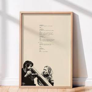 Puede incluir: Impresión enmarcada con una escena de película, con dos personas en la parte inferior y texto de guion en la parte superior. El marco es de madera clara y el fondo es de color beige neutro. La imagen es una fotografía en blanco y negro.