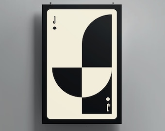 May include: A framed poster of a playing card, the Jack of Spades. The card features a geometric design in black and cream. The spade symbol and the letter "J" are visible.